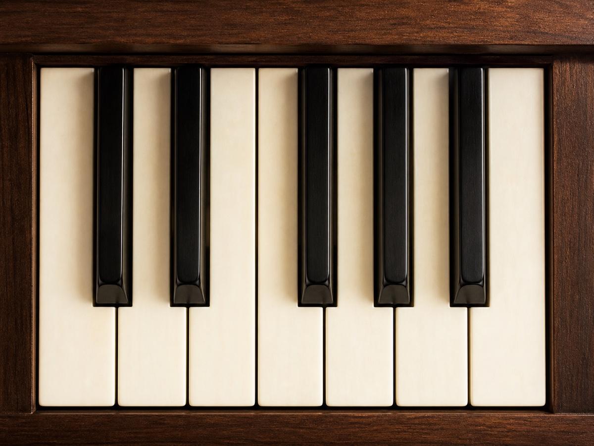 A warmly lit close-up of an elegant wooden piano keyboard